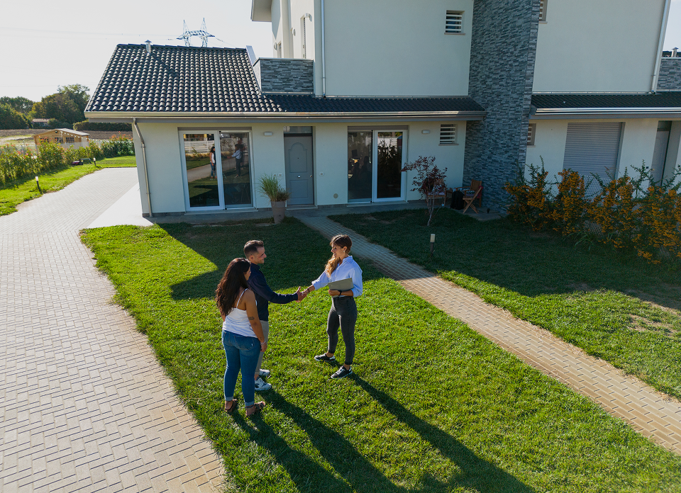 Group greeting on sunny day outside house